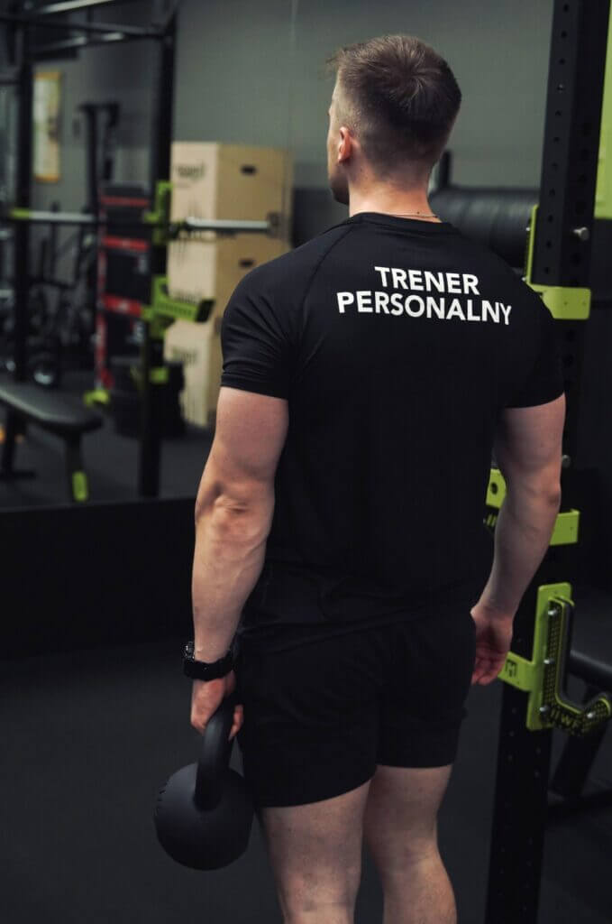 Trener personalny podczas treningu siłowego z kettlebell
